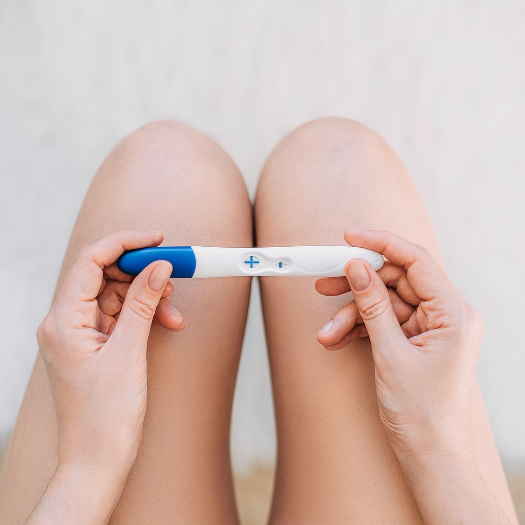 A woman holding a free pregnancy test in Wyandotte and Olathe, Kansas