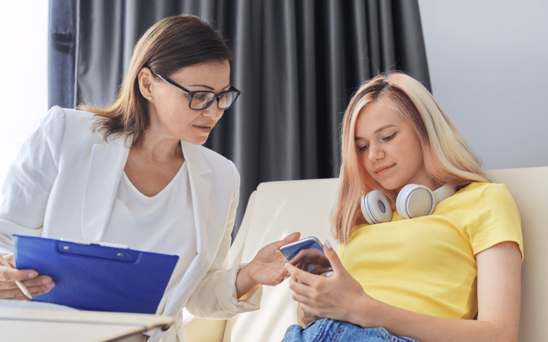 young girl on phone next to therapist